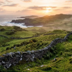 Green hills and a stone wall on the west coast of Ireland at sunrise"